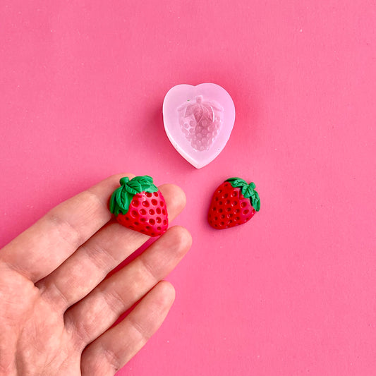 strawberry silicone mold and two polymer clay strawberries