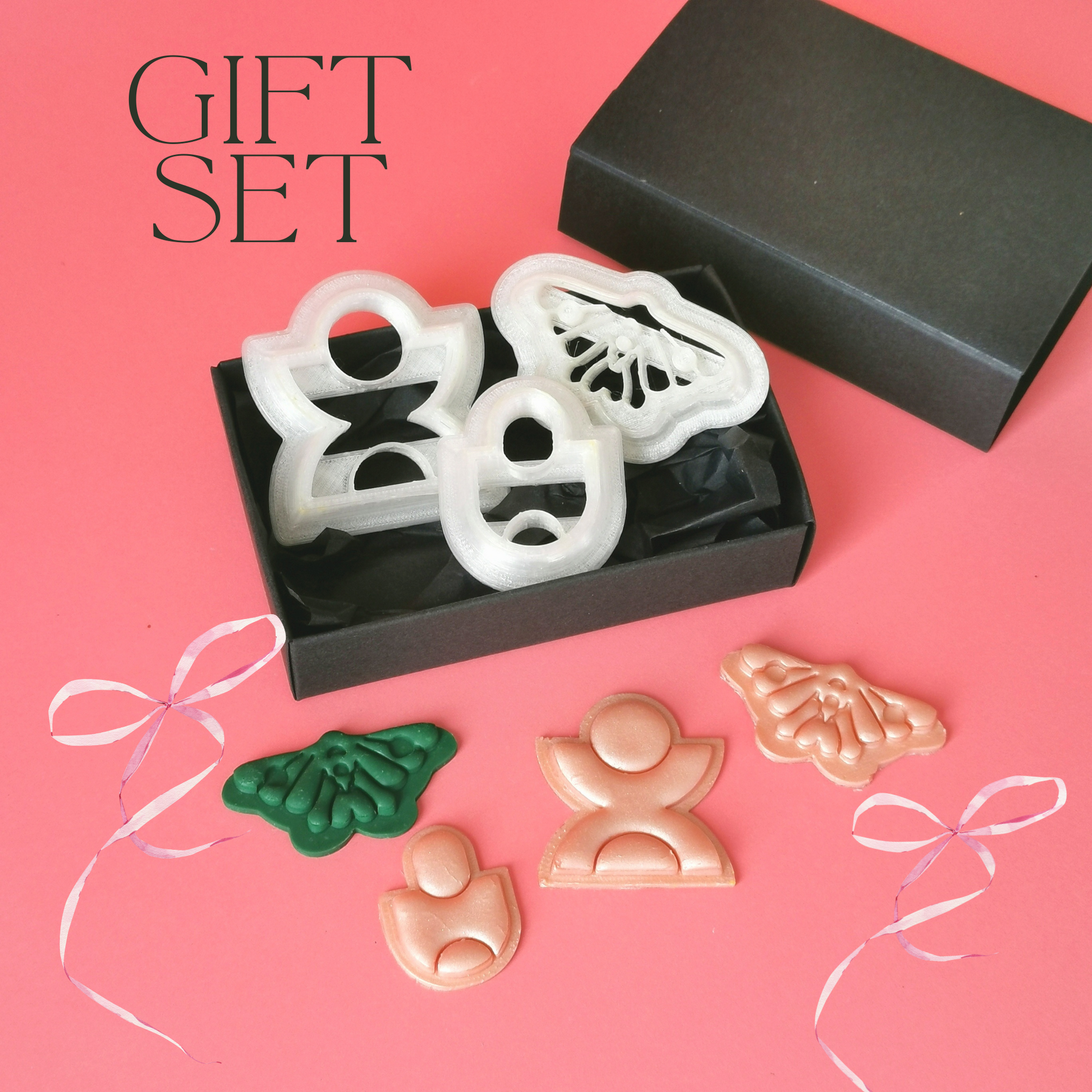 A set of three clay cutters displayed in a box and four polymer clay earrings