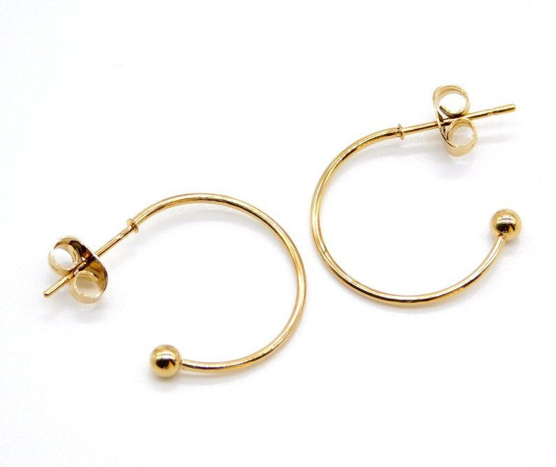 two earring hoops in gold colour on a white background