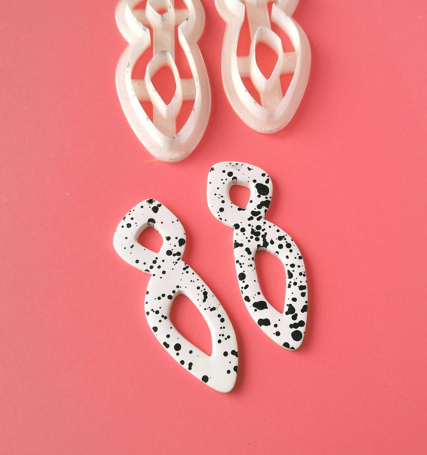 asymmetric long earrings from polymer clay next to cutters