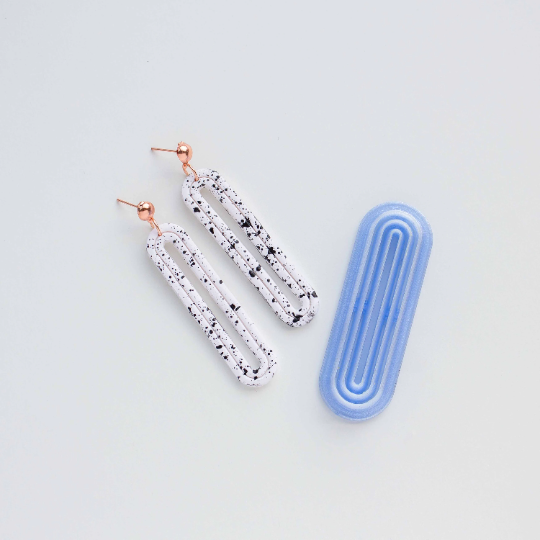 Long oval donut cutter and two donut polyemer clay earrings on a white background.  