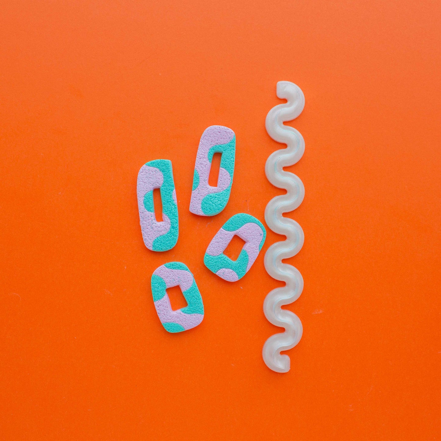 1 wiggle blade and 4 polymer clay shapes in an orange background