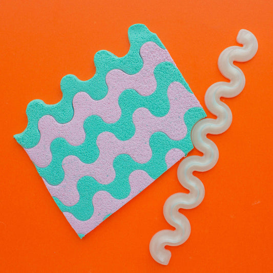 polymer clay colorful slab and 1 wiggle 3d printed blade in an orange background