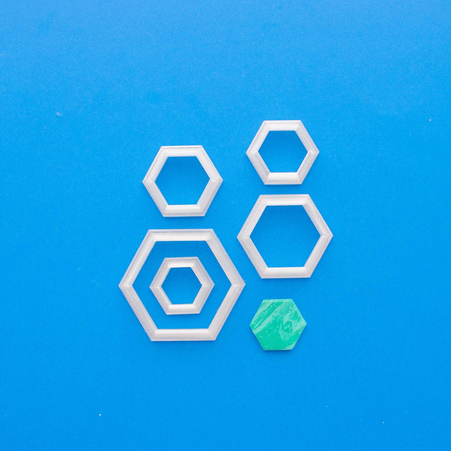 5 hexagon polymer clay cutters in a blue background