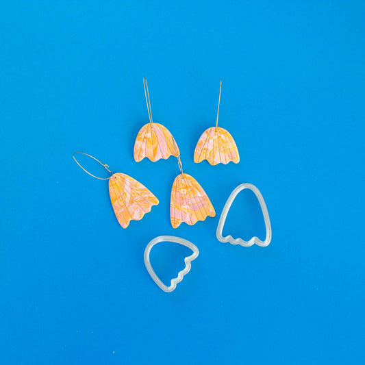 Two abstract flower shaped cutters and four polymer clay earrings