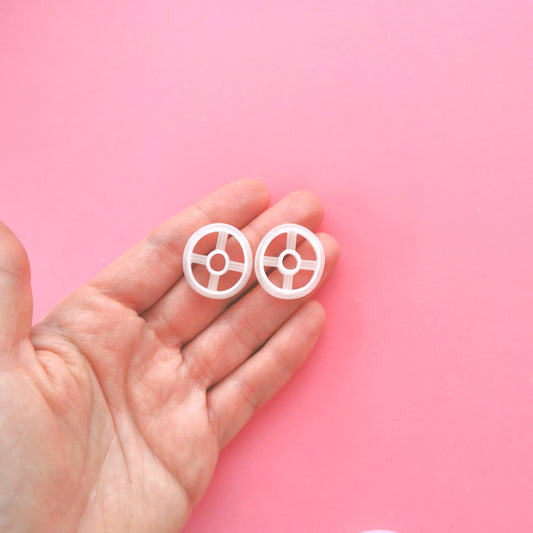 2 small donut circle cutters for clay in a pink background