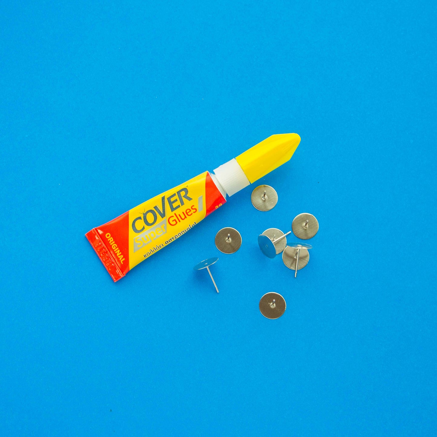 A tube of cover super glue and eight steel studs for earrings