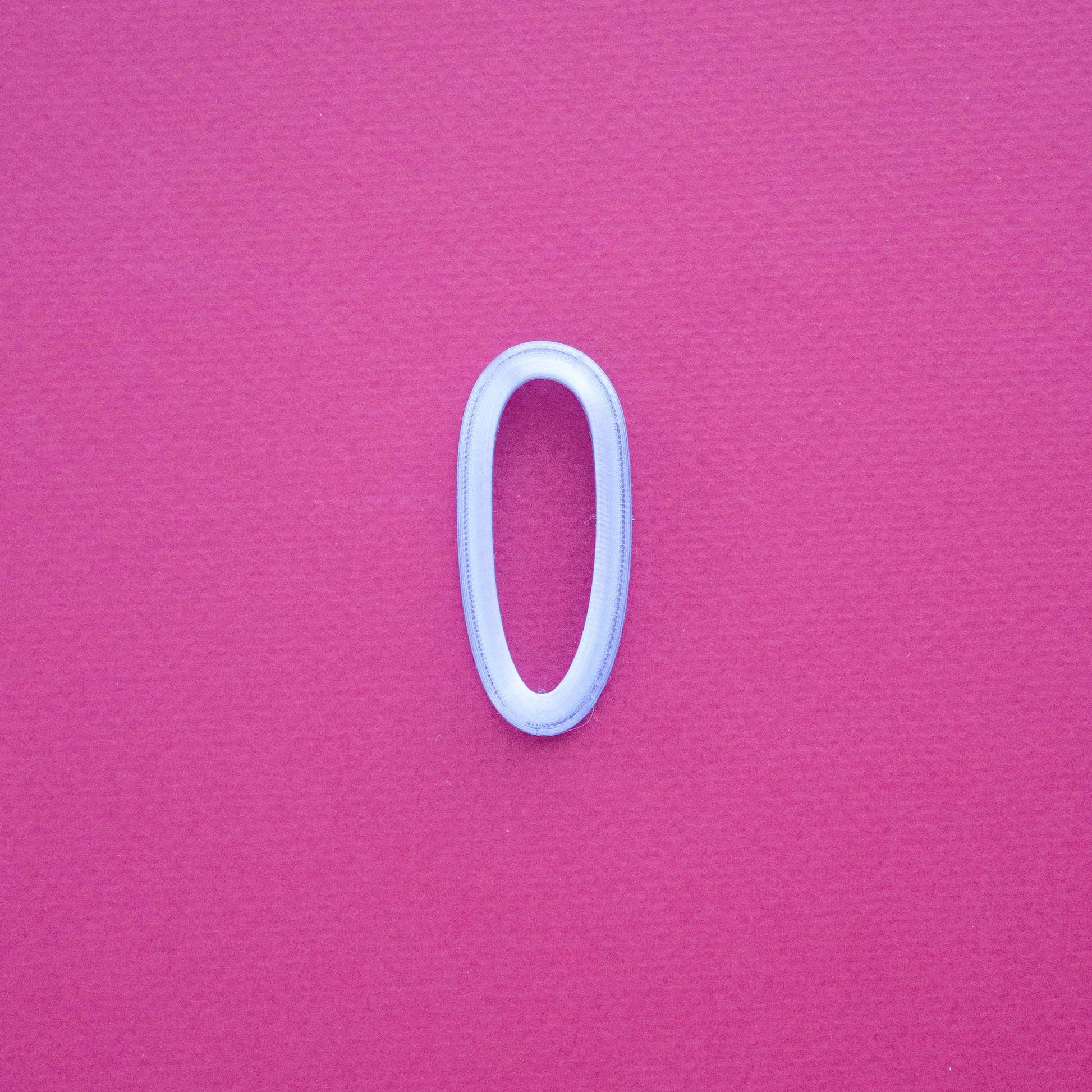 One stud polymer clay cutter on a pink background.