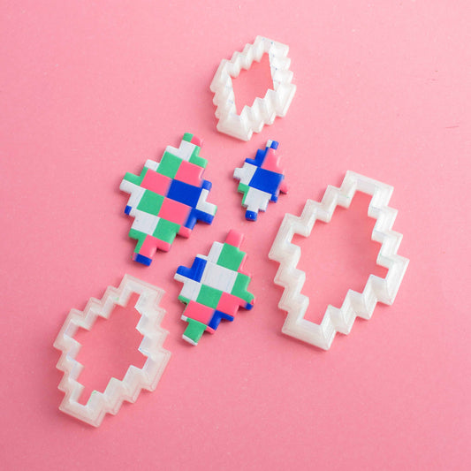 3 rhombus clay cutters and clay shapes on a pink background
