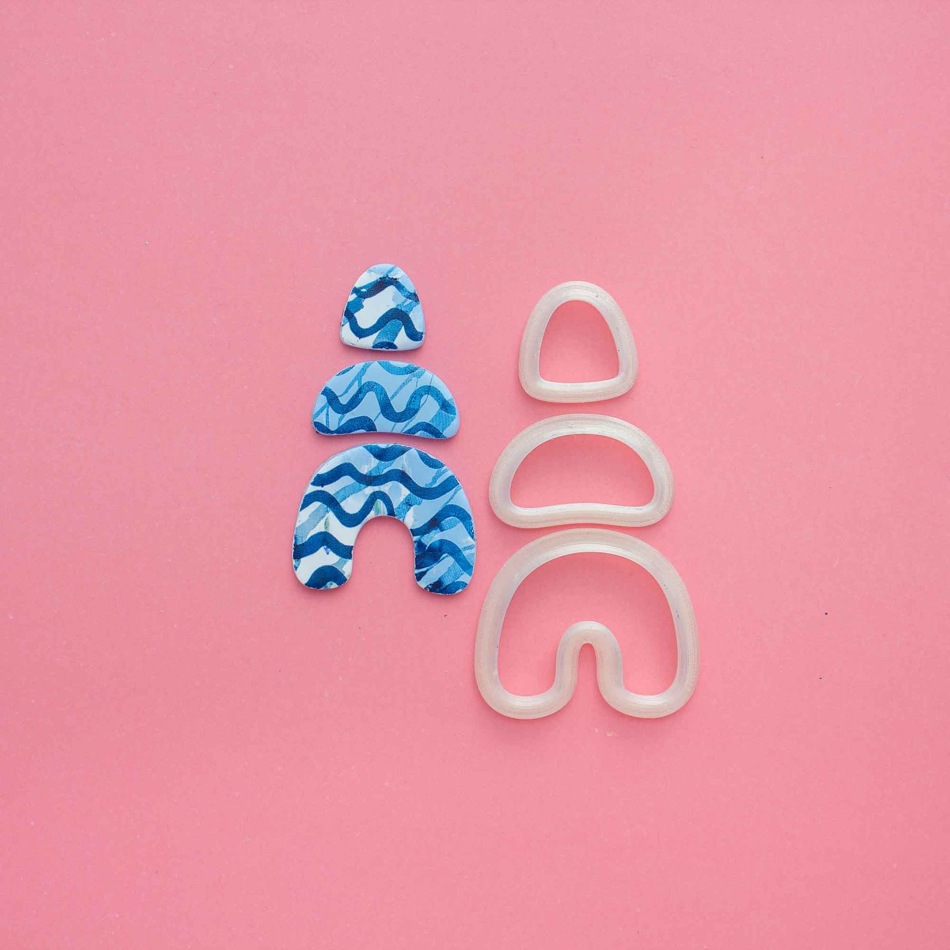 set of 3 organic clay shapes  and 3 clay cutters on a pink background