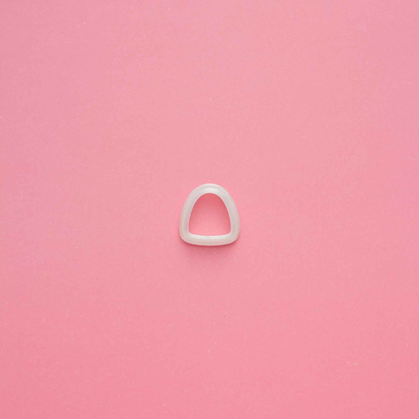 1 clay organic triangle clay cutter on a pink background