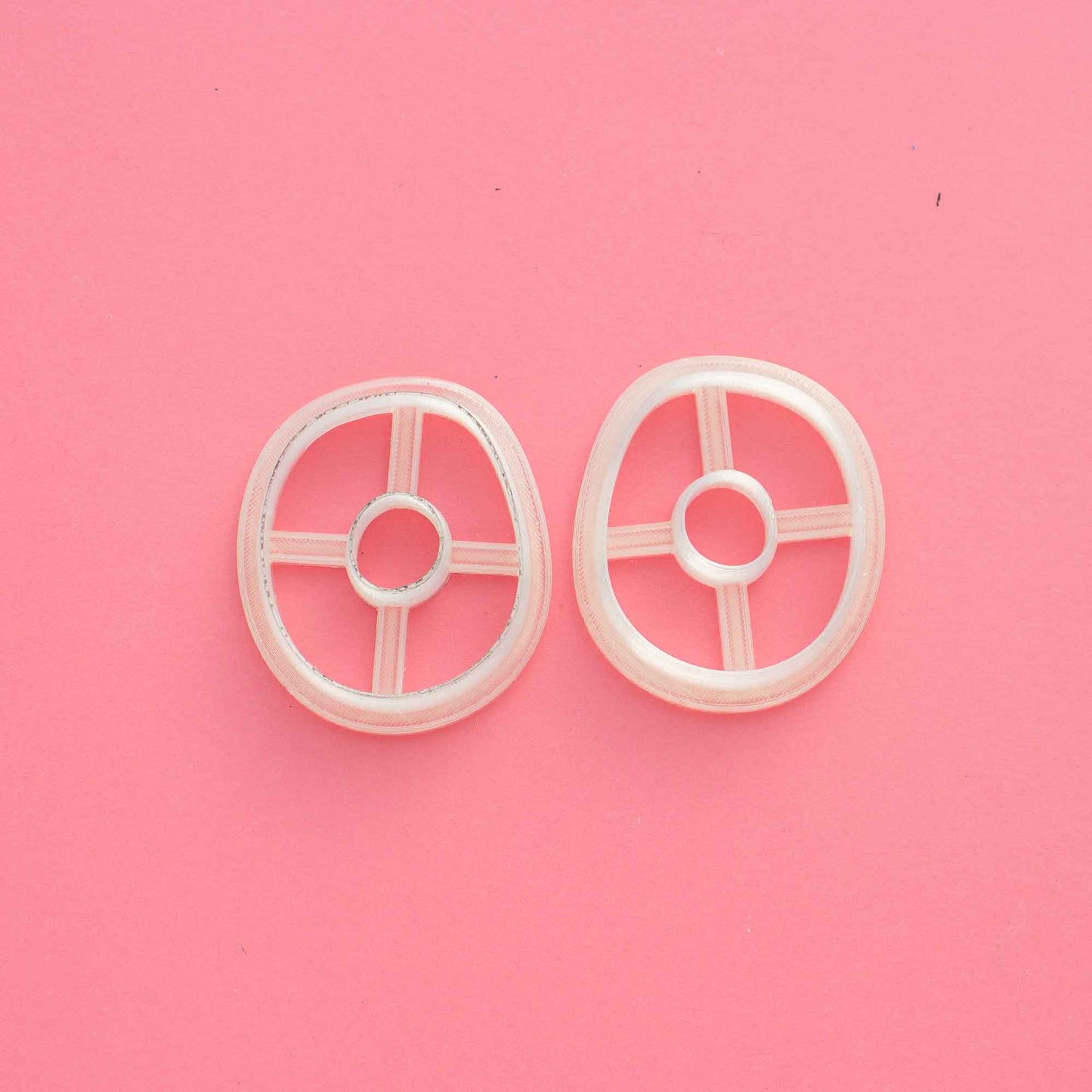 2 mirrored organic circle cutters for clay on a pink background