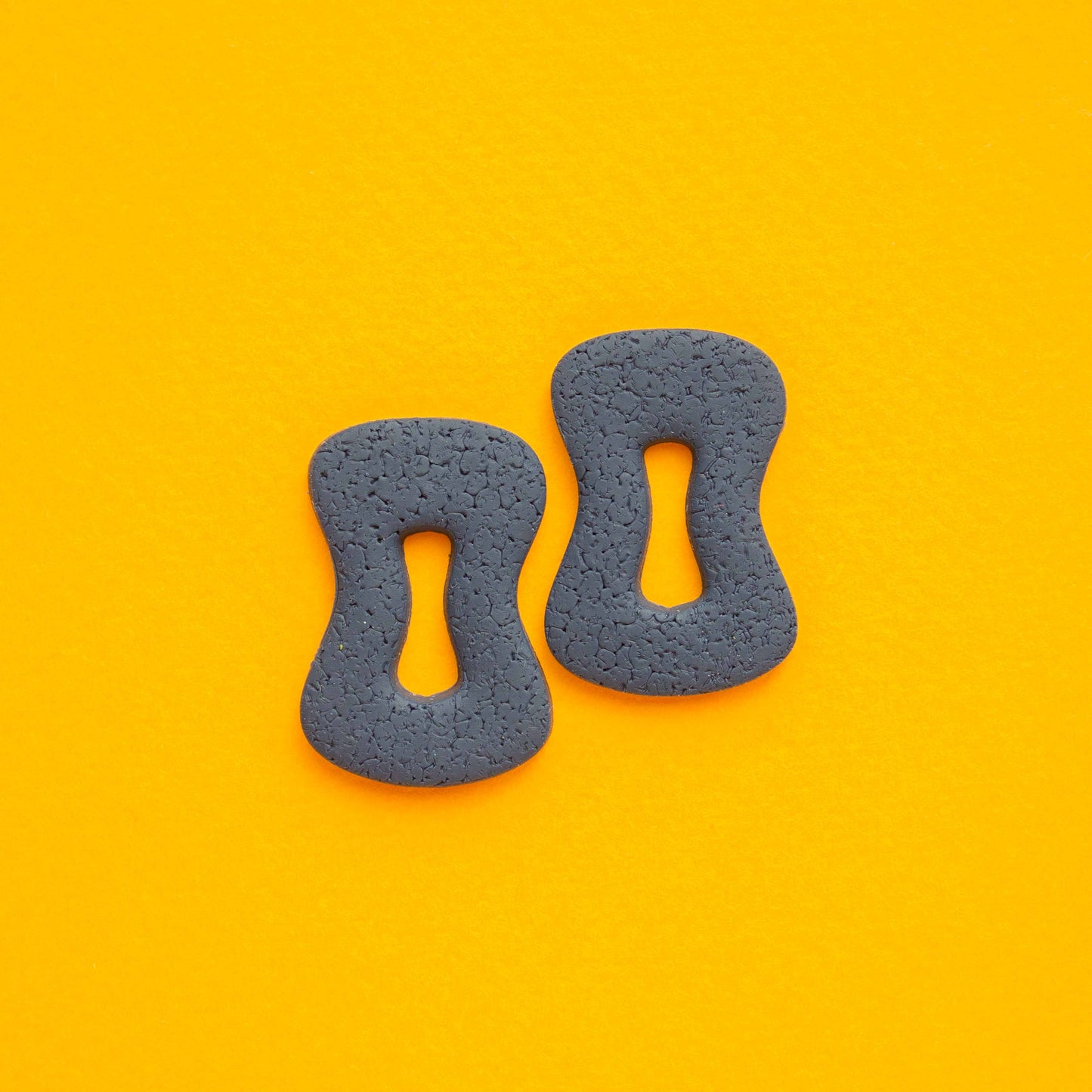 Two polymer clay earings anaglyph, stud part in a yellow background