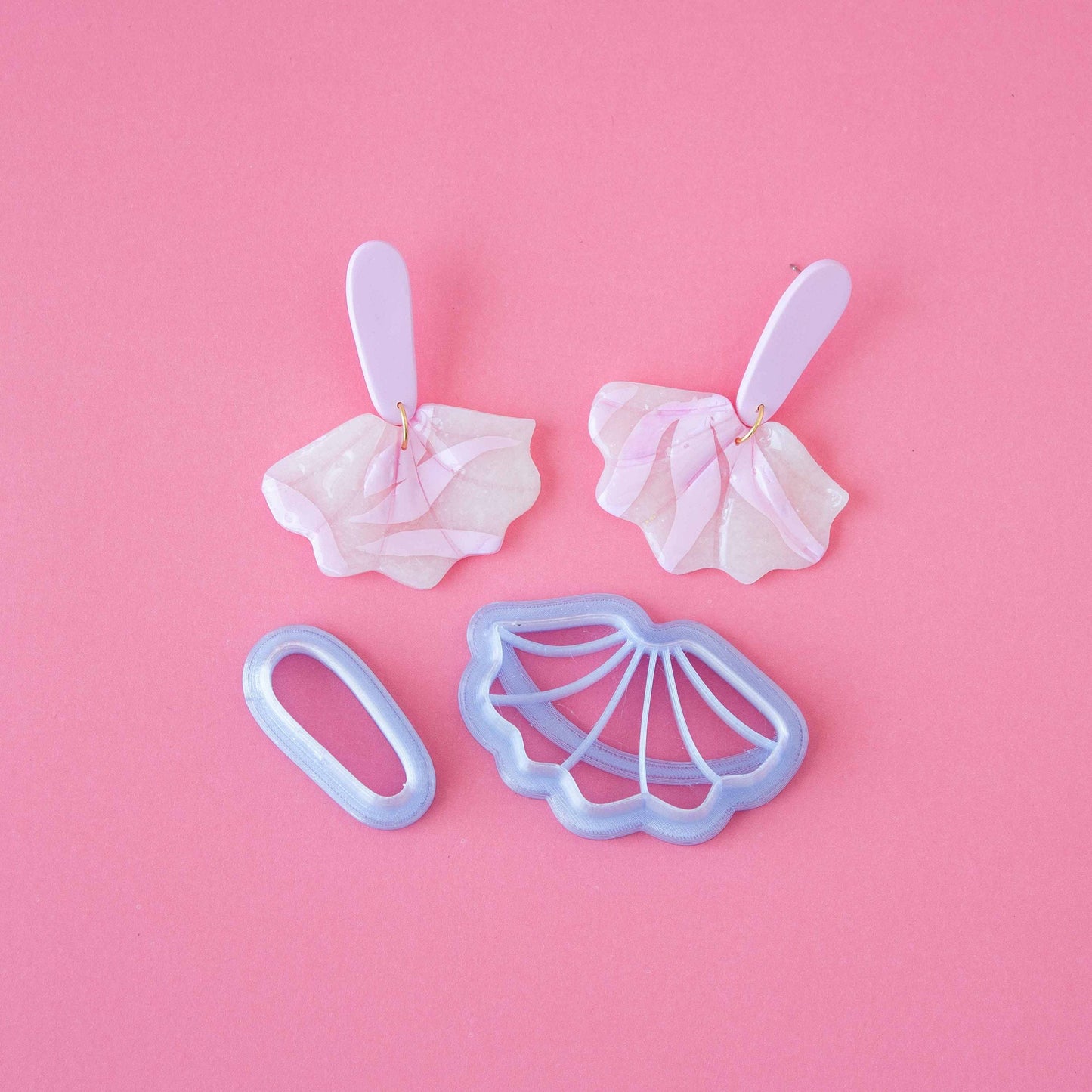 A set of small cutters on a pink background.